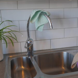 green crotcheted dish cloth in a kitchen by the sink