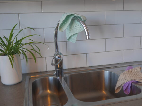 green crotcheted dish cloth in a kitchen by the sink